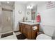 Bathroom featuring granite counters, custom vanity, tiled shower, and modern fixtures at 203 Marlowe Dr, Dunn, NC 28334