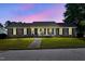Charming brick home with a landscaped front yard and inviting front porch at dusk at 203 Marlowe Dr, Dunn, NC 28334