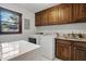 Laundry room with washer, dryer, sink, granite counters, and wooden cabinets at 203 Marlowe Dr, Dunn, NC 28334