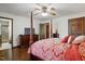 A primary bedroom featuring a wooden four poster bed, wooden floors, and warm, neutral colors at 203 Marlowe Dr, Dunn, NC 28334
