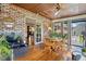 Inviting sunroom featuring brick walls, wood floors and ceiling, large windows, and a dining area at 203 Marlowe Dr, Dunn, NC 28334