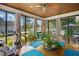 Bright sunroom with wood floors and ceiling, large windows, and a sitting and dining area at 203 Marlowe Dr, Dunn, NC 28334