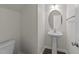 Half bathroom featuring a pedestal sink, modern faucet, and neutral decor at 204 Trevor Ridge Dr, Holly Springs, NC 27540