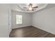 This spacious bedroom features a tray ceiling, a ceiling fan, and a large window at 204 Trevor Ridge Dr, Holly Springs, NC 27540