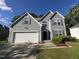 Charming two-story home with gray siding, an attached garage, and well-maintained landscaping at 204 Trevor Ridge Dr, Holly Springs, NC 27540