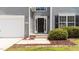 Home's entrance with a black front door, number 204, and well-maintained landscaping at 204 Trevor Ridge Dr, Holly Springs, NC 27540