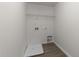 This is a compact laundry area featuring connections for a washer and dryer and wire rack shelving at 204 Trevor Ridge Dr, Holly Springs, NC 27540