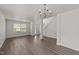 Spacious living room featuring hardwood floors, large windows, and a modern chandelier at 204 Trevor Ridge Dr, Holly Springs, NC 27540