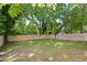 Newly fenced backyard with mature trees and a lush green lawn at 205 S Pettigrew St, Raleigh, NC 27610