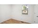 Empty bedroom showing wood floors, white walls, trim, and a window with blinds at 205 S Pettigrew St, Raleigh, NC 27610
