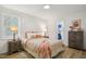 Cozy bedroom with light-colored walls, hardwood floors, two end tables, and natural light at 205 S Pettigrew St, Raleigh, NC 27610