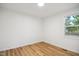 Unfurnished bedroom showing wood floors, white walls, trim, and a window with blinds at 205 S Pettigrew St, Raleigh, NC 27610