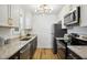 This modern kitchen features stainless appliances, stone countertops, and black lower cabinets at 205 S Pettigrew St, Raleigh, NC 27610