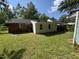 Backyard of the home, featuring green grass and mature trees at 2131 Dandridge Dr, Raleigh, NC 27610