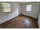 Bedroom featuring light-colored walls, wood-look flooring, and natural light from two windows at 2131 Dandridge Dr, Raleigh, NC 27610