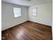 Bright bedroom featuring wood-look flooring, two windows, and white walls at 2131 Dandridge Dr, Raleigh, NC 27610