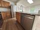 Kitchen featuring stainless steel dishwasher, wood cabinets, and light countertops at 2131 Dandridge Dr, Raleigh, NC 27610