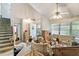 Bright living room with vaulted ceilings, a ceiling fan, and a staircase visible on the left at 2308 Stonesthrow Ct, Raleigh, NC 27610