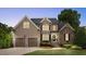Charming two-story home featuring a three car garage, brick accents, and a well-manicured lawn at 233 Hein Dr, Clayton, NC 27527