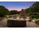 Inviting stone outdoor fireplace with seating area, perfect for entertaining in this serene backyard setting at 233 Hein Dr, Clayton, NC 27527