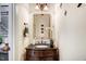 Stylish half-bathroom featuring a vanity with a dark wood finish, decorative mirror, and modern accents at 233 Hein Dr, Clayton, NC 27527