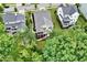 Aerial view of back of houses, decks, screened porches, and green lawn interspersed with mature trees at 2409 Plowridge Rd, Fuquay Varina, NC 27526