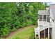 Beautiful backyard with lush trees, manicured landscaping, and a glimpse of the home's deck at 2409 Plowridge Rd, Fuquay Varina, NC 27526