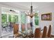 Dining room with glass table, chandelier, and sliding doors to outdoor living space at 2409 Plowridge Rd, Fuquay Varina, NC 27526