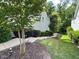 A lush side yard features mature trees, mulch beds and a staircase leading to the property at 2409 Plowridge Rd, Fuquay Varina, NC 27526