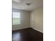 Bedroom featuring a window with blinds, dark floors, neutral walls, and a door at 2612 Beagle Landing Dr, Raleigh, NC 27610
