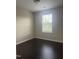 Bedroom with dark floors, a window with blinds, neutral walls, and a ceiling light at 2612 Beagle Landing Dr, Raleigh, NC 27610