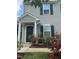 View of the home's covered front porch and garden with rose bushes at 2612 Beagle Landing Dr, Raleigh, NC 27610