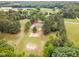 Lush green property featuring a charming home nestled among mature trees and open fields, providing a serene setting at 2712 Nc 57, Hillsborough, NC 27278