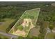 Aerial view of the property showing the house and the boundaries of its lot surrounded by trees at 2712 Nc 57, Hillsborough, NC 27278