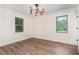 Spacious bedroom with luxury vinyl plank flooring, crown moulding, and two windows overlooking nature at 2712 Nc 57, Hillsborough, NC 27278