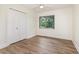Well-lit bedroom featuring luxury vinyl plank flooring, white trim, neutral colored walls, and a double-door closet at 2712 Nc 57, Hillsborough, NC 27278