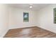Well-lit bedroom featuring luxury vinyl plank flooring, white trim, neutral colored walls, and a window with views of the outside at 2712 Nc 57, Hillsborough, NC 27278