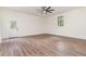 Large living room with wood-look floors, ceiling fan, and natural light coming in through the window and glass-panel door at 2712 Nc 57, Hillsborough, NC 27278