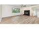 Inviting living room featuring wood-look floors, recessed lighting, natural light from the large window, and a fireplace at 2712 Nc 57, Hillsborough, NC 27278