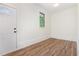 Entry way into the house featuring wood-look flooring, white trim and neutral walls, with a window and paneled door at 2712 Nc 57, Hillsborough, NC 27278