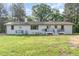 Rear view of the white brick house with a spacious backyard and deck at 2712 Nc 57, Hillsborough, NC 27278