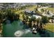 Aerial view of community amenities featuring a pool, clubhouse, green spaces, lake and surrounding neighborhood at 277 Douglas Falls Dr, Wendell, NC 27591