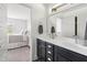 Stylish bathroom with double vanity, dark cabinetry, and a mirror reflecting a view into the bedroom at 277 Douglas Falls Dr, Wendell, NC 27591