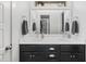 Bright bathroom with a dual sink vanity, marble countertop, and black cabinetry at 277 Douglas Falls Dr, Wendell, NC 27591