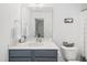 Bright bathroom with a marble countertop, framed mirror, and black vanity at 277 Douglas Falls Dr, Wendell, NC 27591