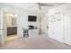 Bright bedroom with adjoining bathroom, flat screen TV, and white display shelves at 277 Douglas Falls Dr, Wendell, NC 27591