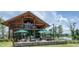 Clubhouse featuring outdoor dining area with patio and a view of a lake, surrounded by lush greenery at 277 Douglas Falls Dr, Wendell, NC 27591