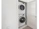 A compact laundry closet featuring a stacked washer and dryer with a louvered door at 277 Douglas Falls Dr, Wendell, NC 27591