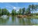 Community pond with dock and fountain featuring views of the clubhouse and nature trails at 277 Douglas Falls Dr, Wendell, NC 27591