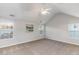 A bright bedroom features neutral walls and carpet, vaulted ceiling, and natural light from the three windows at 2902 Framer Ln, Durham, NC 27704